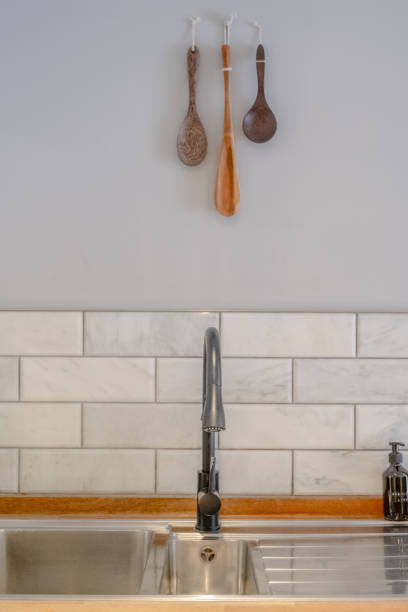 istock Kitchen Sink and Tap with Wooden Utensils on the Wall 1440085373