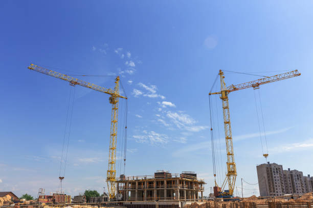istock Crane and building construction site against blue sky. 1440086334