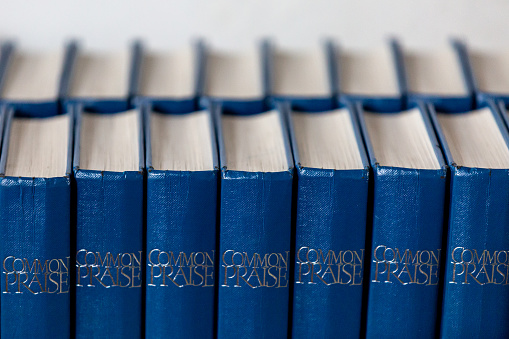 Cover of an old blue book on a black background. The book is unfolded. Side view.