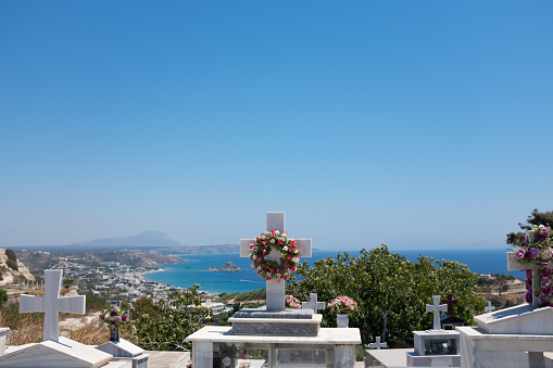 Greek cemetery with white marble tombs with the mediterranean sea in the background