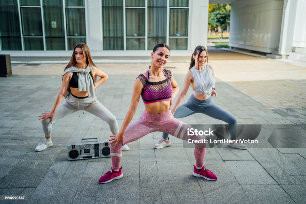 Group of young women dancing modern dance Group of young women dancing modern dance choreography outdoors Active Lifestyle Stock Photo