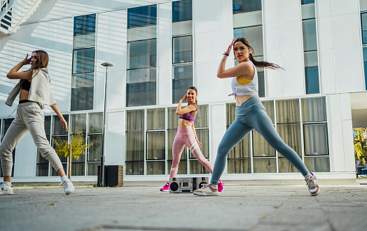 Group of young women dancing modern dance choreography outdoors