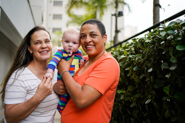 portrait of lesbian couple with baby - homosexual family lesbian parent imagens e fotografias de stock