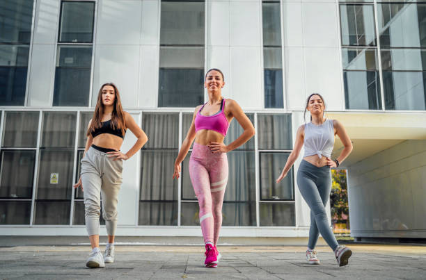 Young female dancers performing outdoors Group of young female dancers practicing their performance outdoors dance troupe stock pictures, royalty-free photos & images