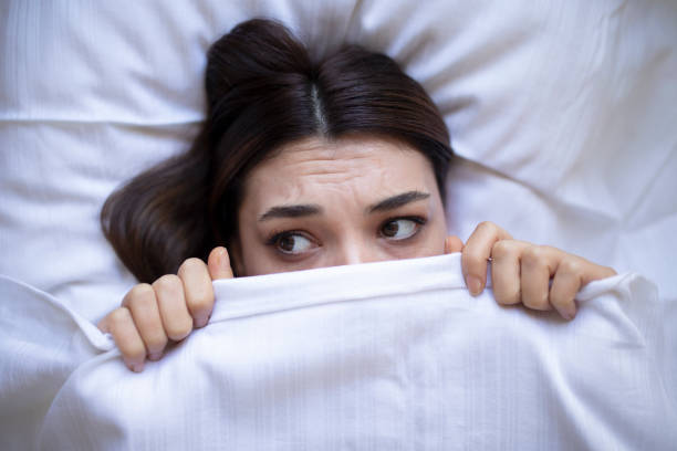 istock scary woman looking under blanket 1440093037