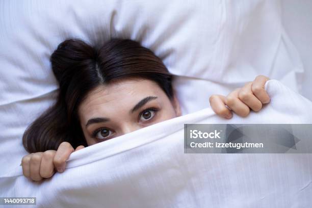 Scary Woman Looking Under Blanket Stock Photo - Download Image Now - Hiding, Human Face, Insomnia