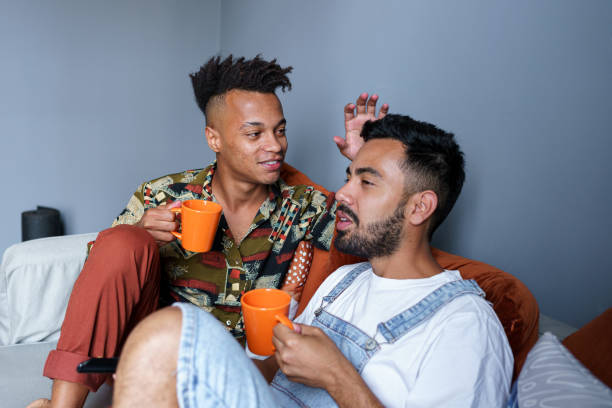 istock Happy couple sitting on sofa watching television and drinking tea 1440094938