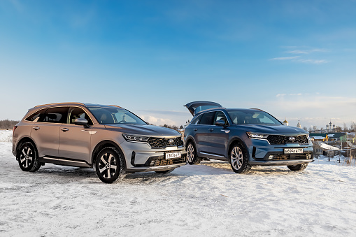 Suzdal, Russia - November 8, 2022: Two Kia Sorento all-wheel drive full-size crossovers are standing on the street. Winter