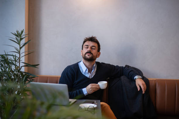istock Young businessman having his coffee break after a long hard day at work 1440095579