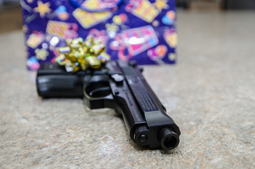 Golden gift bow on handgun