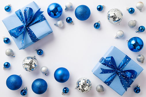 Christmas Eve concept. Top view photo of blue white silver baubles disco balls and big present boxes with ribbon bows on isolated white background with copyspace in the middle