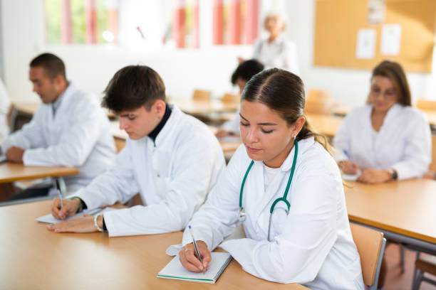 istock Doctors different age sitting at desk in classroom working during lesson at education class 1440098877