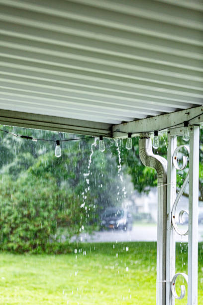 istock Drenching Downpour Rain Water Dripping Under Edge of Roof 1440101569
