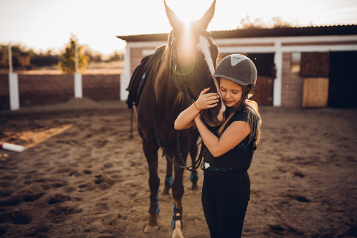 A girl hugs her horse