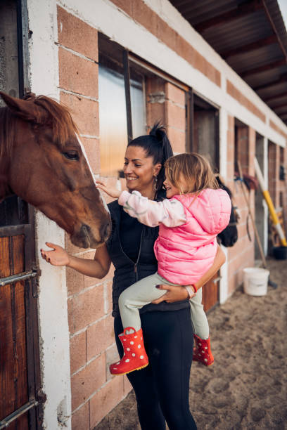 istock Mother and daughter with a horse 1440103671