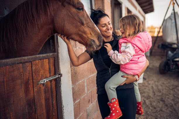 istock Mother and daughter with a horse 1440103723