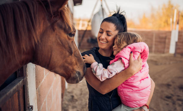 istock Mother and daughter with a horse 1440103724