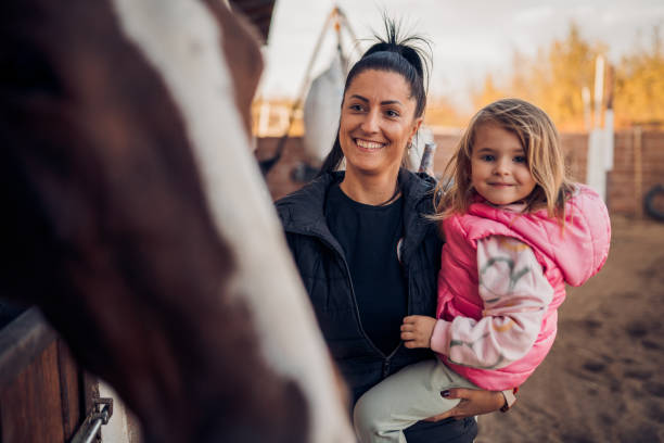 istock Mother and daughter with a horse 1440103725