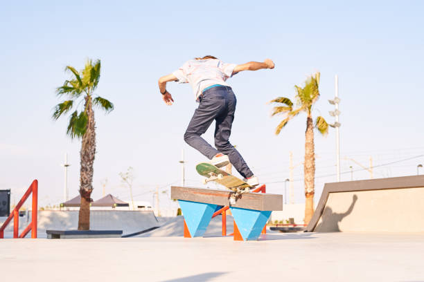 istock Back view of professional skateboarder performing trick 1440105023