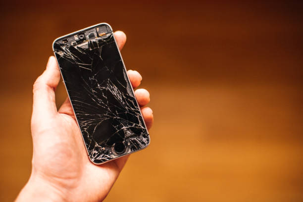 istock Person holding in hand broken smart phone with cracked screen 1440107148