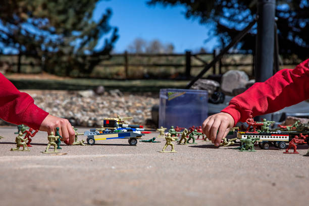 Two hands reaching in to play with small toys