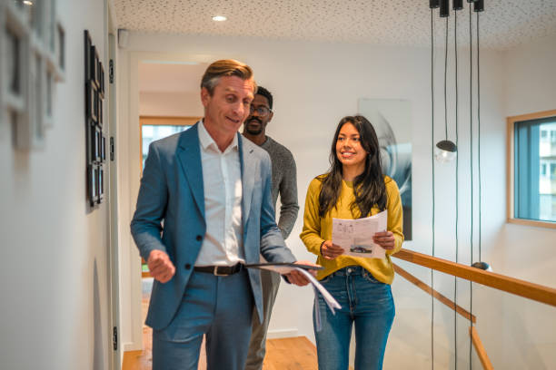 istock Professional Salesman Working And Showing A Modern House To A Young  Multi-Ethnic Married Couple 1440110785