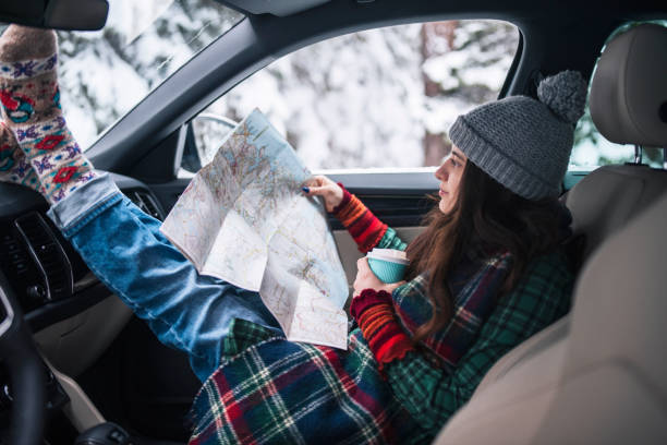 istock Woman on a winter road trip reading a map. 1440111239