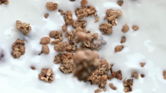 Yogurt granola dessert breakfast closeup. Tasty muesli falling creamy liquid