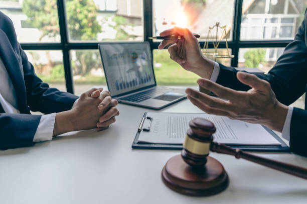 Businessmen and lawyers discuss contract documents. Treaty Law. business contract and legal documents and study information about common court cases with the scales of justice and the hammer next to it. stock photo