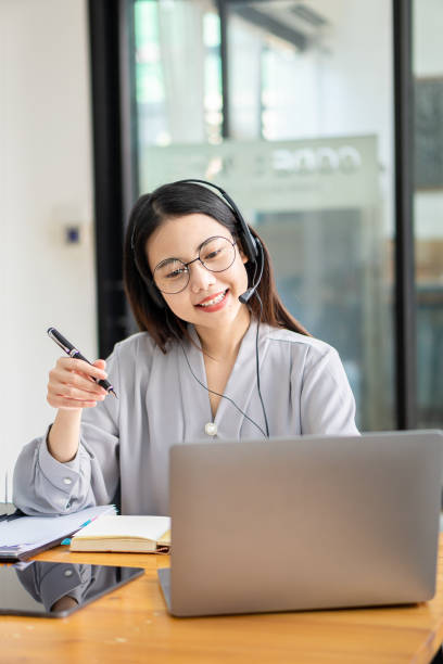 concetto di studio autonomo
donna asiatica che indossa le cuffie, guarda il laptop, si diverte con l'apprendimento online con videochiamata con tutor. ascolta la narrazione audio guarda il webinar - financial occupation audio foto e immagini stock