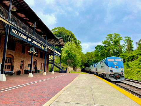 Lynchburg, Virginia, USA - May 8, 2022: The Amtrak “Crescent” passenger train pulls into Lynchburg’s Kemper Street Station on a cloudy Spring day.