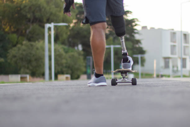 istock Back view of man with disability skating on sunny day 1440127099