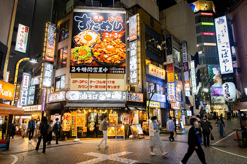 Tokyo, Japan - October 15, 2022: Bright neon lights of Shinjuku district in Tokyo at night crowded