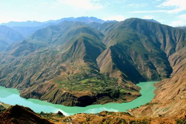Jinsha River is the upper and trunk of the Yangtze River. In the picture, the river is about 1,600 m asl. In the distance, the highest peak of Jade Dragon  Snow Mountain is 5,596 m.