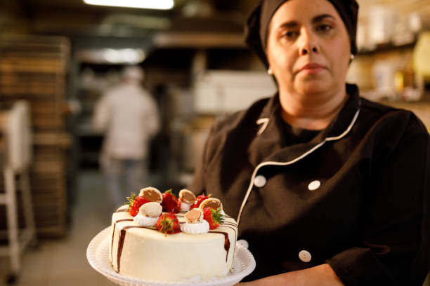 istock Pastry chef holding a chocolate and strawberry cake 1440131542