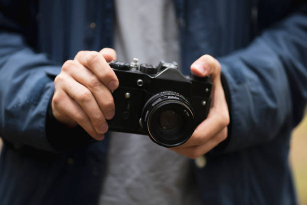 istock person holding retro metal camera and adjusting settings 1440132392