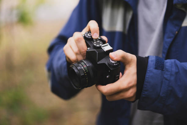 istock person holding retro metal camera and adjusting settings 1440132394