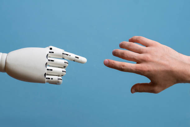 istock robotic arm touching human hand, man and machine friendship 1440133338