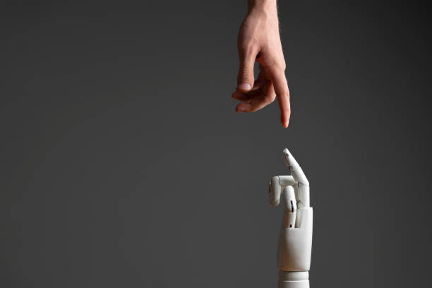 istock robotic arm touching human hand, man and machine friendship 1440133346