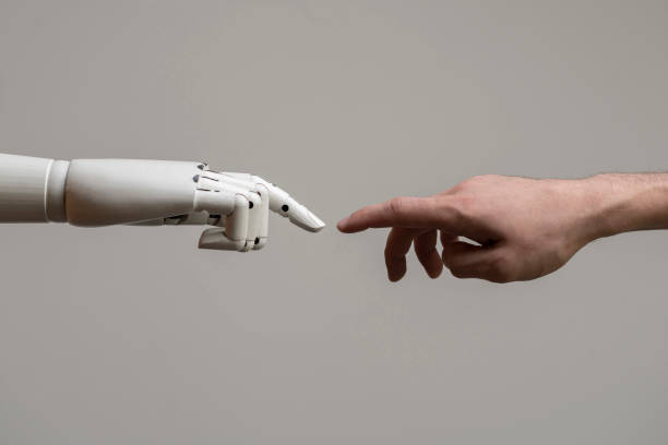 istock robotic arm touching human hand, man and machine friendship 1440133351