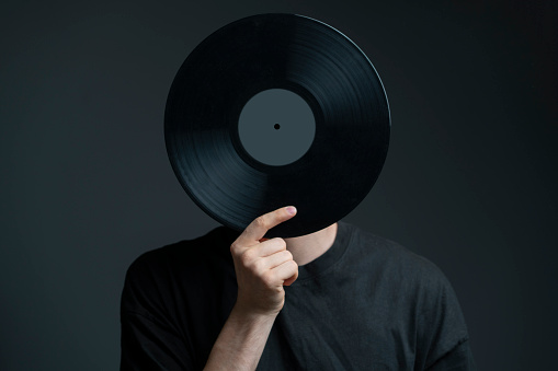 holding a vinyl record disc in front of head