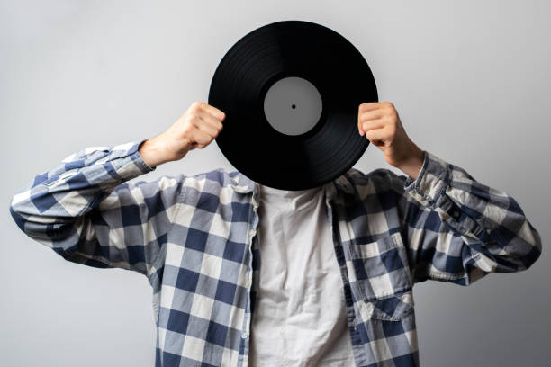 istock holding a vinyl record disc in front of head 1440133809