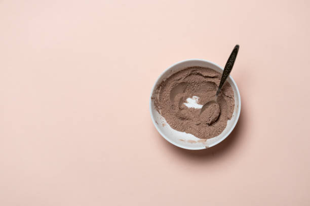 top view of brown sweet cocoa powder in white bowl