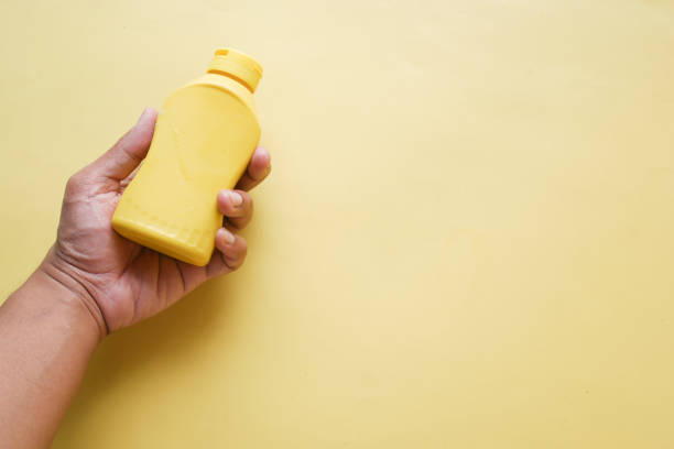 istock holding a mustard mayonnaise container on yellow background 1440137236