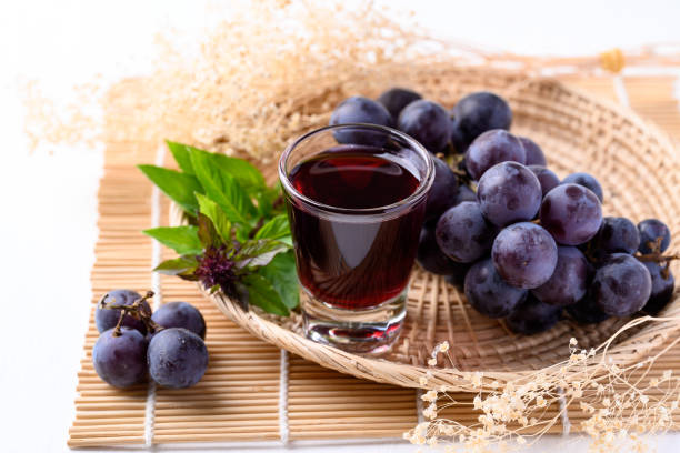 Black grape and juice in glass stock photo