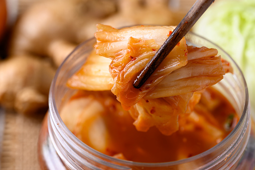 Kimchi cabbage in bowl eating by chopsticks, Asian fermented food