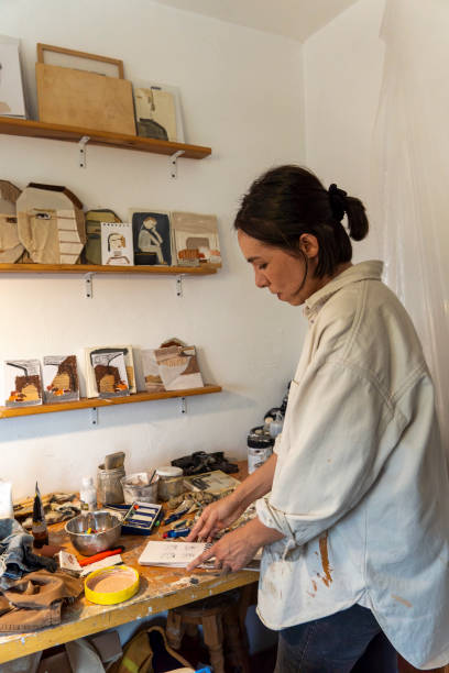 istock young latin woman, in her own painting studio, creates paintings different artistic techniques 1440141396