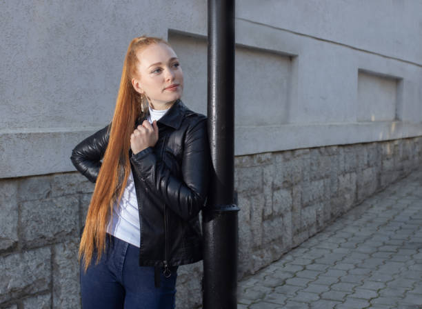 красивая девушка, модель, в кожаной курт�ке, с длинными волосами позирует на улице - life jacket despair business life стоковые фото и изображения
