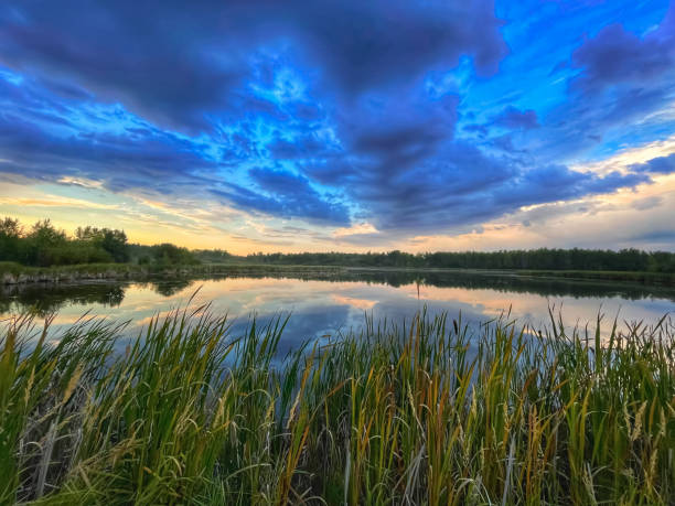 istock Cloudy blue dramatic sky over the lake during the sunset. 1440149632