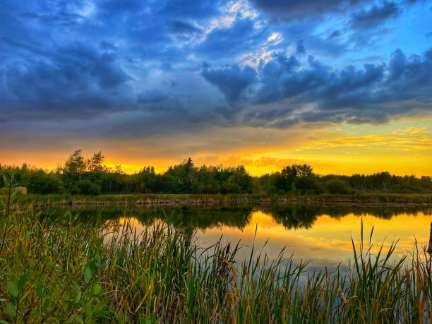 istock Cloudy blue dramatic sky over the lake during the sunset. 1440149640